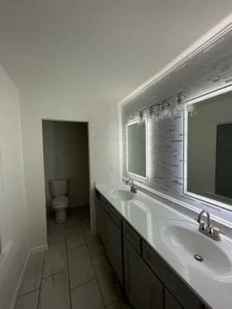 a bathroom with a double vanity sink and mirror