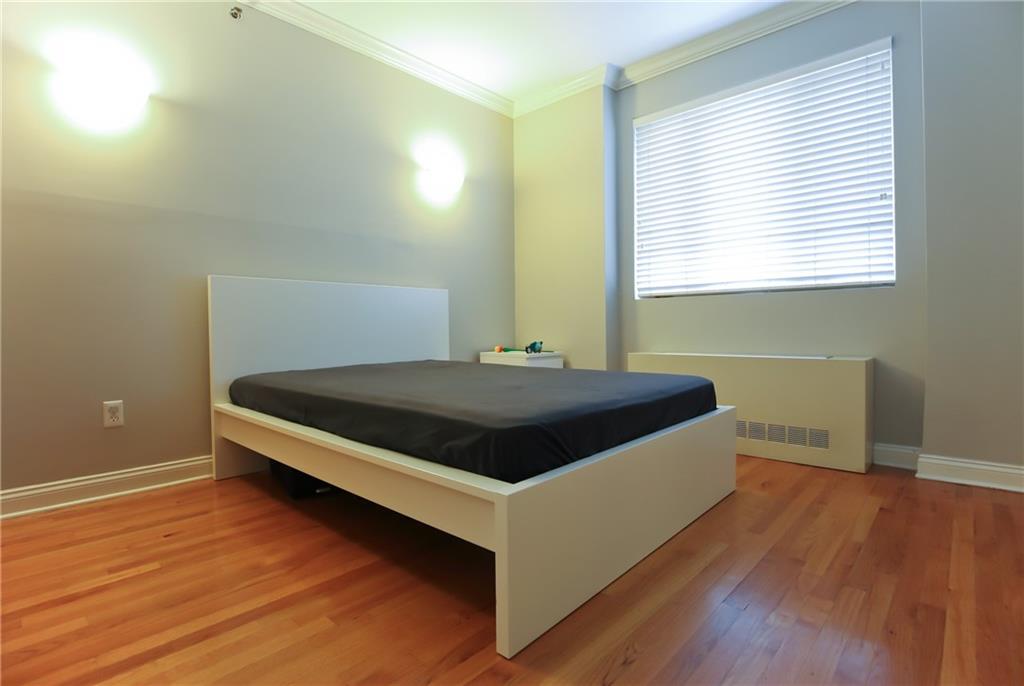 9935 Shore Road, Unit 1D Brooklyn, NY 11209 - Photo 8 of 10 a large bed sitting in a bedroom next to a window
