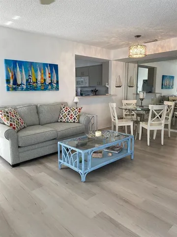 a living room with furniture wooden floor and a flat screen tv