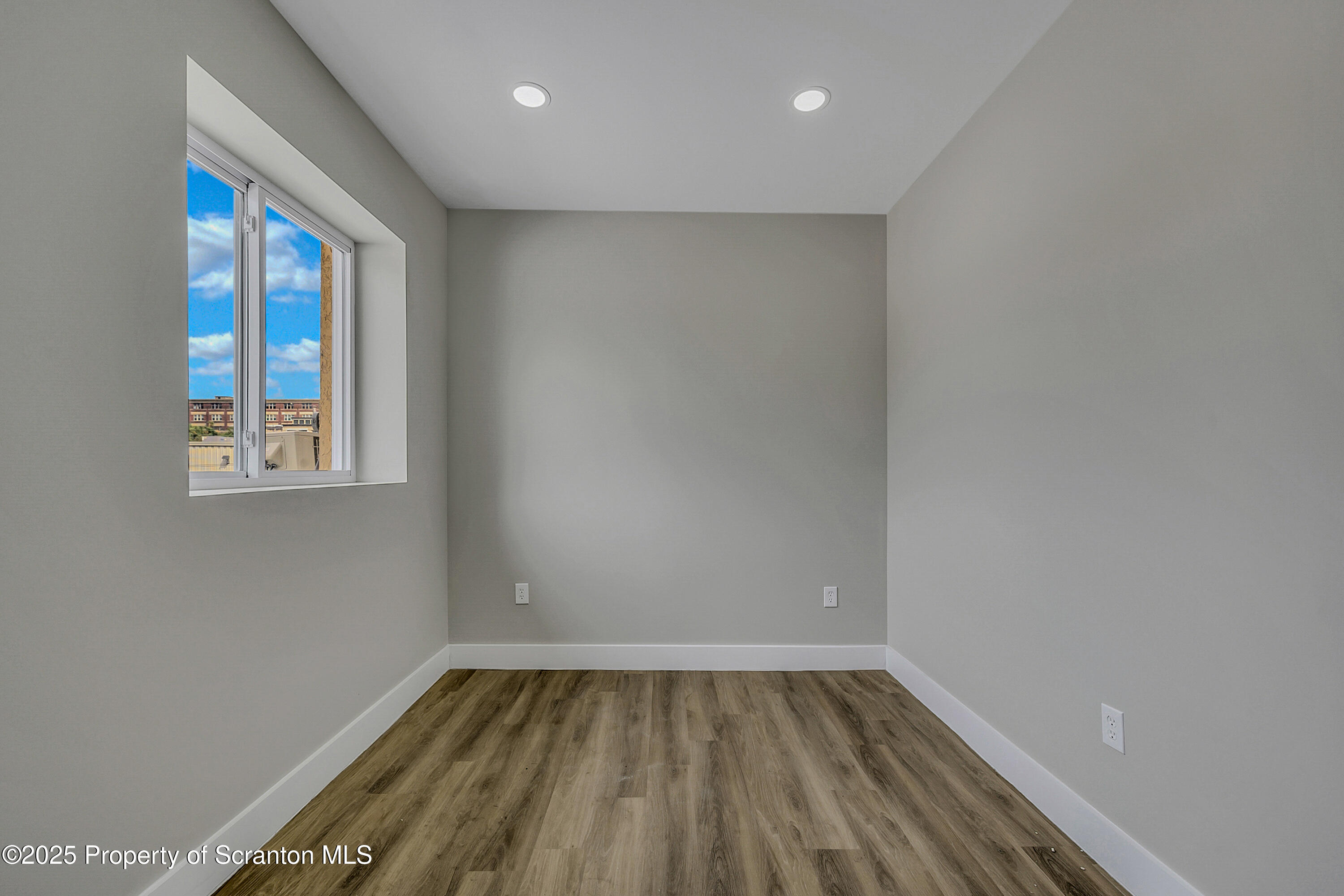 215 Hickory Street, Unit 11 Scranton, PA 18505 - Photo 12 of 13 a view of an empty room with wooden floor and a window