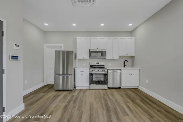 a view of kitchen with refrigerator and cabinets