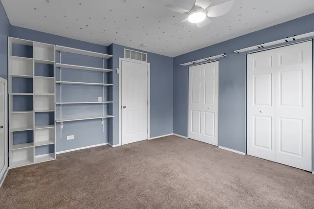 a view of an empty room with a closet and a window