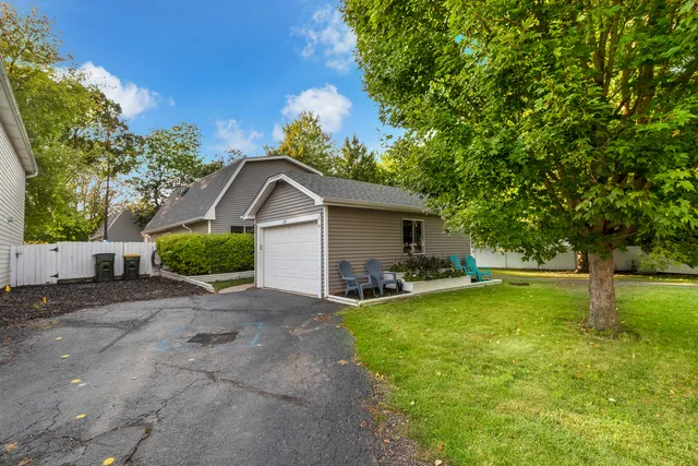 a view of a house with backyard and a tree