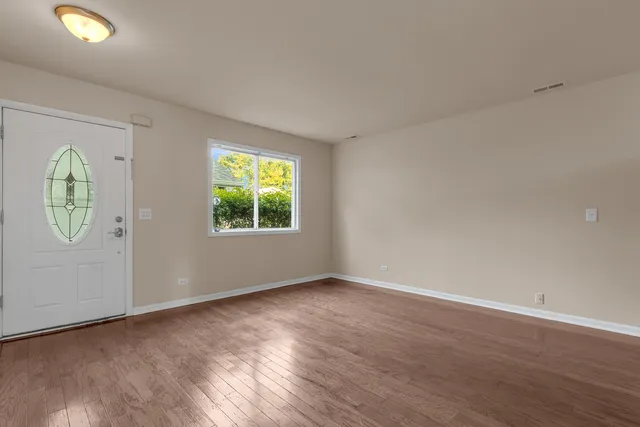 an empty room with windows and mirror