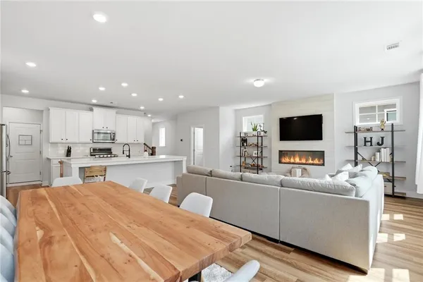 a living room with stainless steel appliances furniture and a flat screen tv