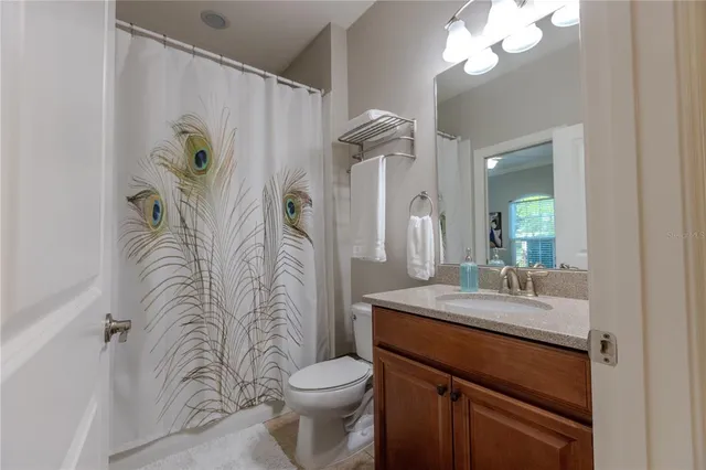 a bathroom with a granite countertop sink a toilet and a mirror