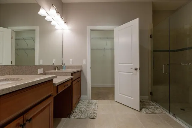 a bathroom with a granite countertop sink a mirror and a shower