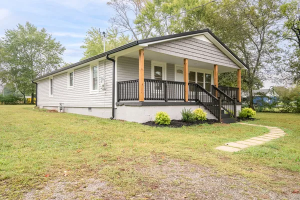 a front view of a house with yard and green space