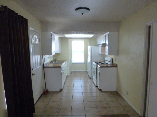 5006 Sara Drive, Unit A Austin, TX 78721 - Photo 4 of 10 a kitchen with a refrigerator and a stove