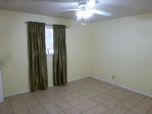 an empty room with closet and a chandelier fan