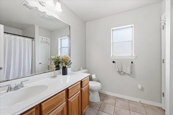 a bathroom with a granite countertop sink a toilet and mirror