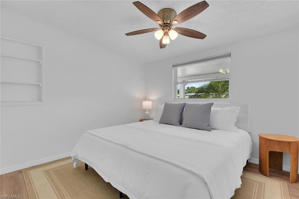 2048 Holiday Lane Naples, FL 34104 - Photo 13 of 28 a bedroom with a large bed and a chandelier