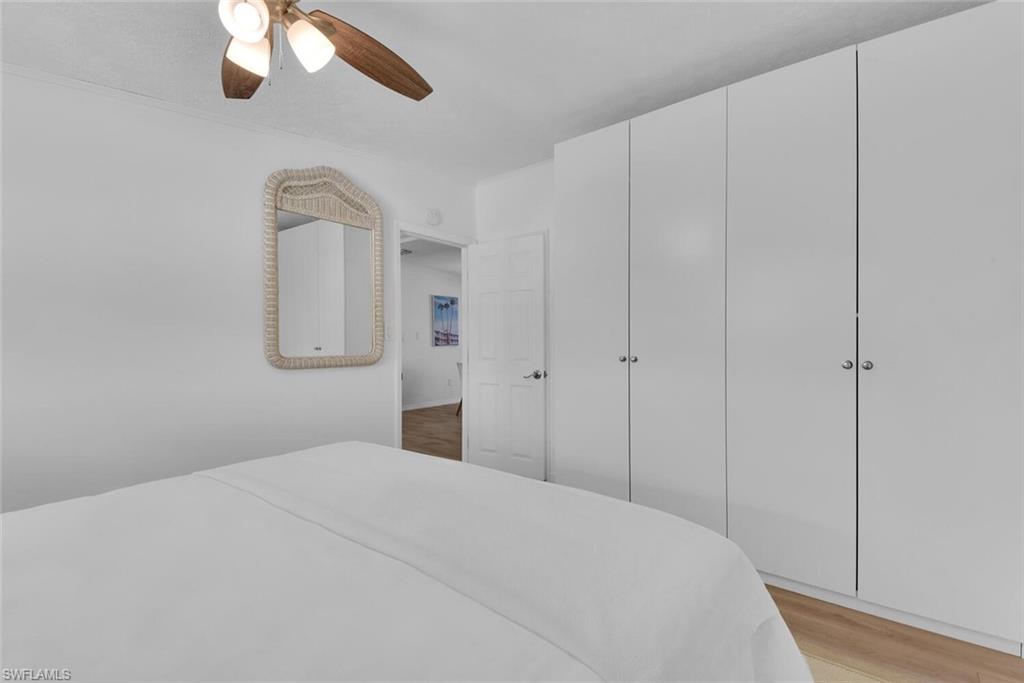 2048 Holiday Lane Naples, FL 34104 - Photo 14 of 28 a bedroom with a bed and a chandelier