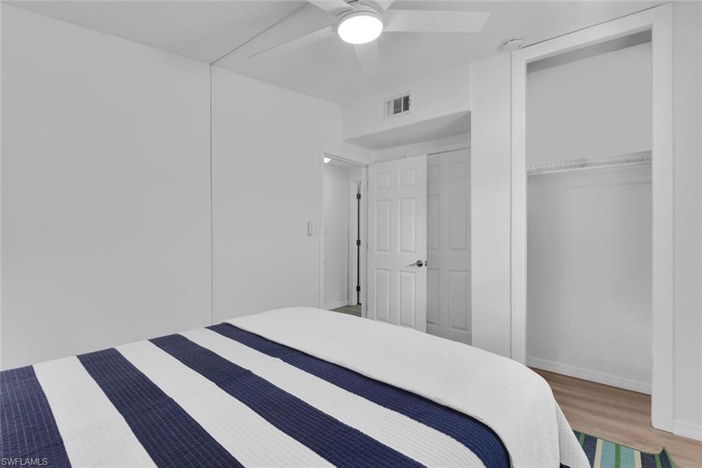 2048 Holiday Lane Naples, FL 34104 - Photo 19 of 28 a bedroom with a bed and a lamp