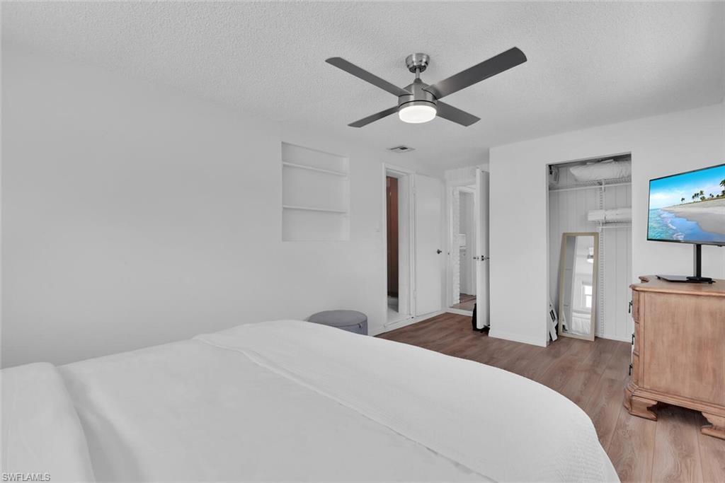 2048 Holiday Lane Naples, FL 34104 - Photo 22 of 28 a bedroom with a large bed and a chandelier