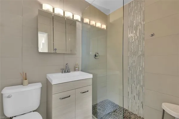 a bathroom with a sink a toilet and shower