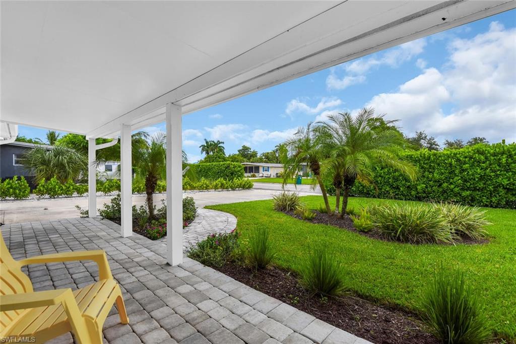 2048 Holiday Lane Naples, FL 34104 - Photo 25 of 28 a front view of a house with garden