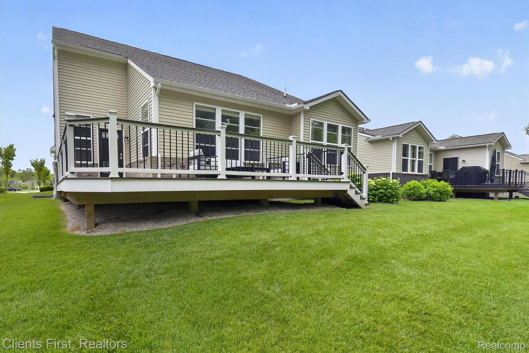 4699 Bingham Road Canton, MI 48188 - Photo 41 of 47 Expansive green lawn with a multi-level deck featuring white railings and black balusters