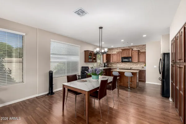 a kitchen with stainless steel appliances kitchen island granite countertop a dining table chairs stove a refrigerator and a window