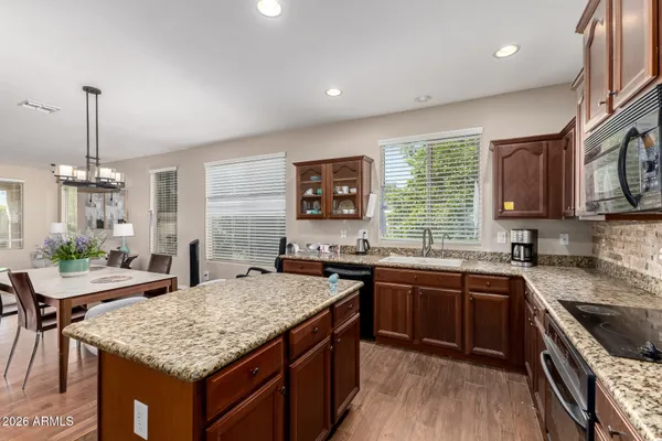 a kitchen with granite countertop sink stove and cabinets