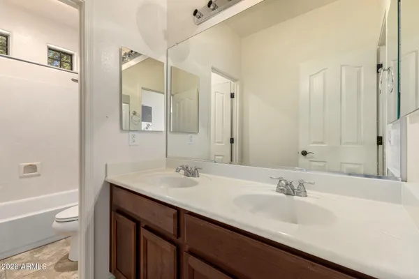 a bathroom with a sink double vanity granite tub shower and a mirror