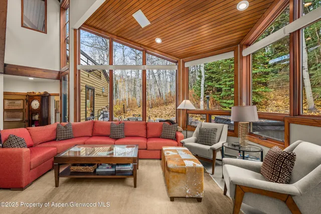 a living room with furniture a flat screen tv and a large window