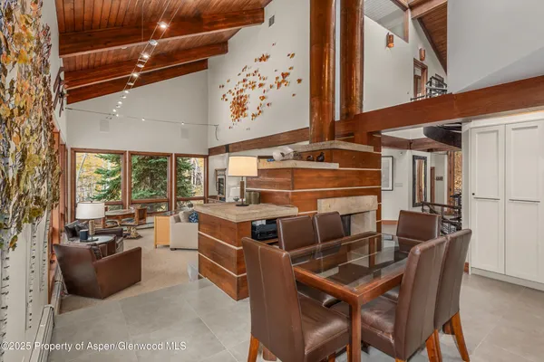 a dining room with furniture and a floor to ceiling window
