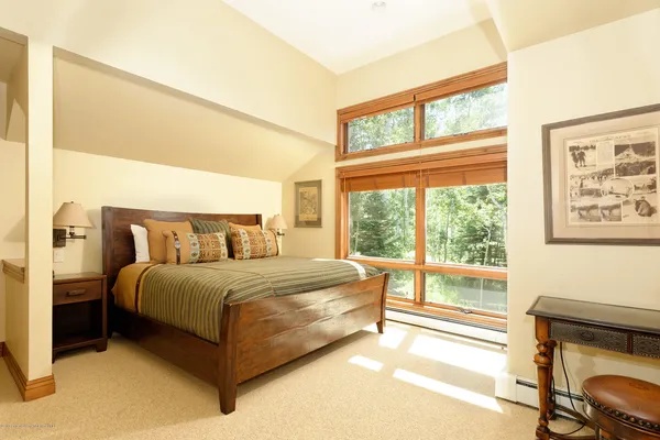 a bed sitting in a bedroom next to a window