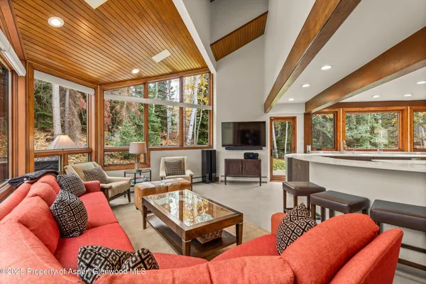 a living room with furniture a flat screen tv and a large window
