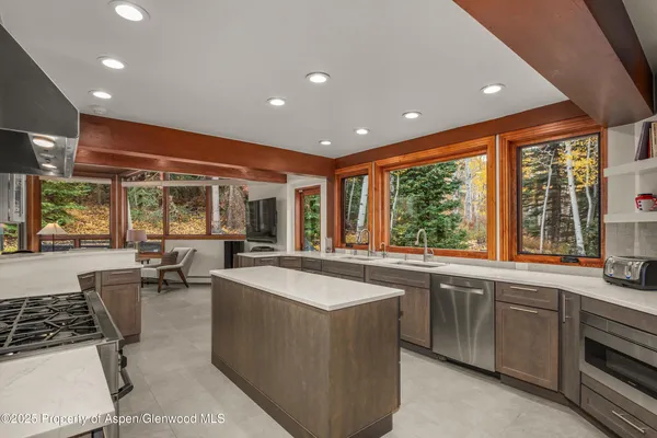 a large kitchen with kitchen island a sink and a large window