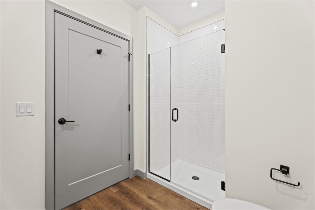 203 Lowell Street, Unit 103 Wilmington, MA 01887 - Photo 18 of 39 a bathroom with a glass shower door