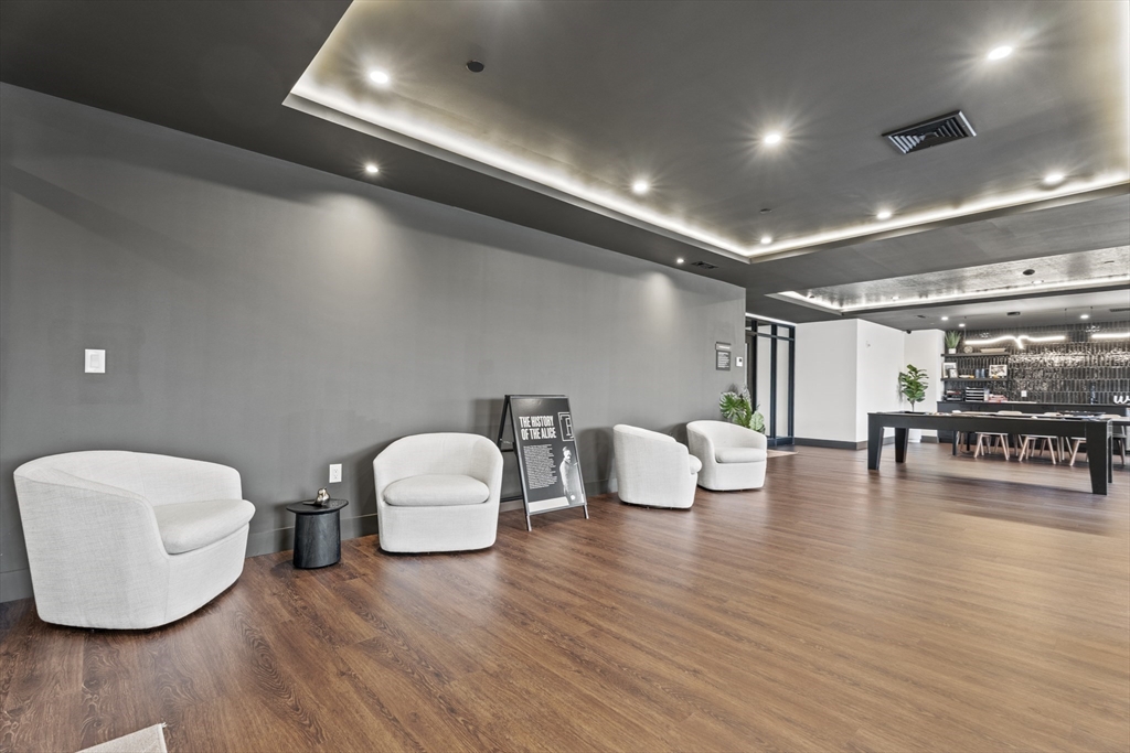 203 Lowell Street, Unit 103 Wilmington, MA 01887 - Photo 24 of 39 a living room with furniture and wooden floor