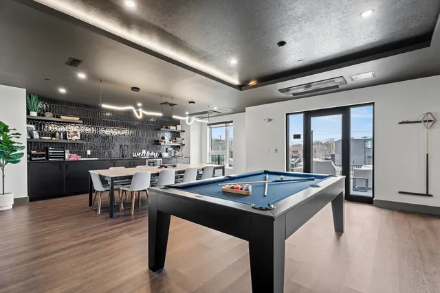a kitchen with a table chairs and wooden floor