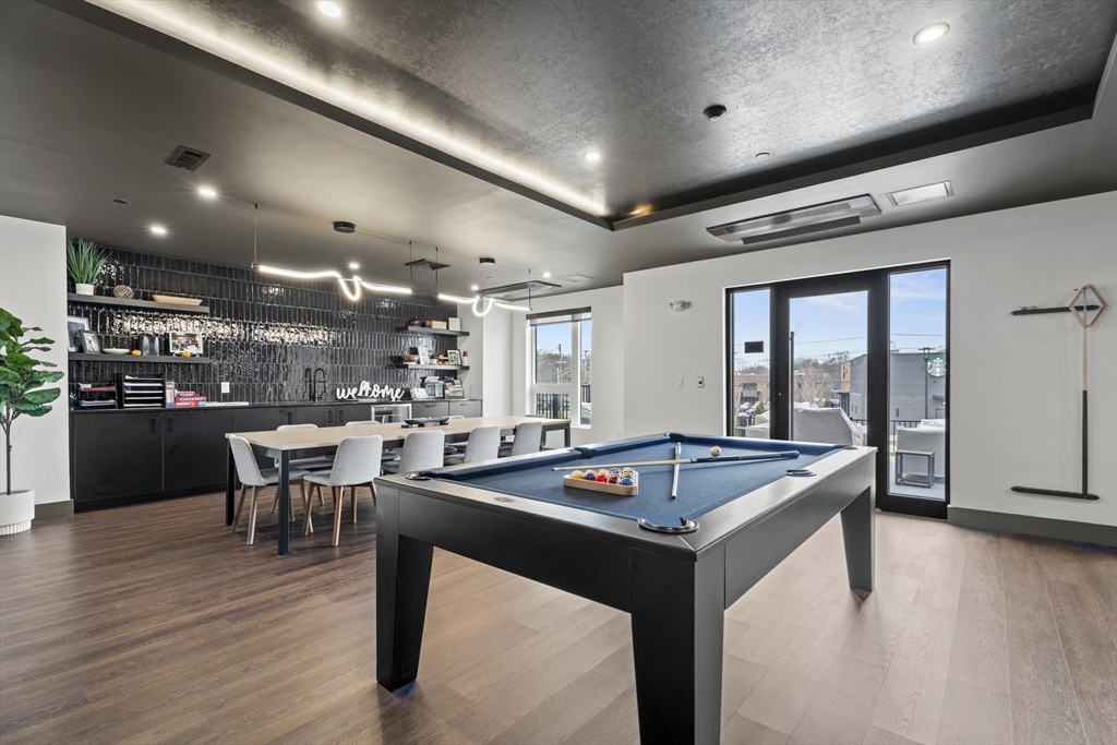 203 Lowell Street, Unit 103 Wilmington, MA 01887 - Photo 25 of 39 a kitchen with a table chairs and wooden floor