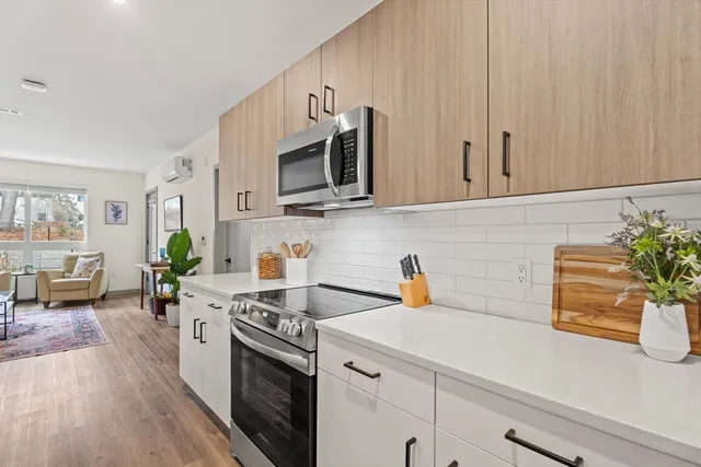a kitchen with stainless steel appliances white cabinets and wooden floor
