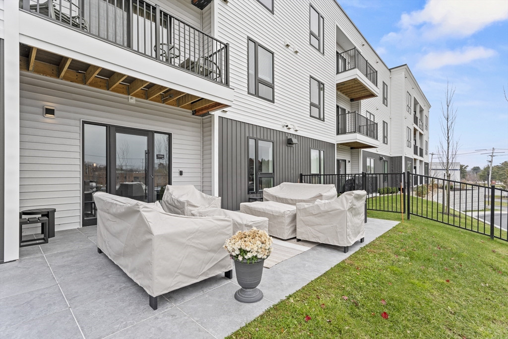 203 Lowell Street, Unit 103 Wilmington, MA 01887 - Photo 34 of 39 a view of a patio with couches table and chairs and potted plants