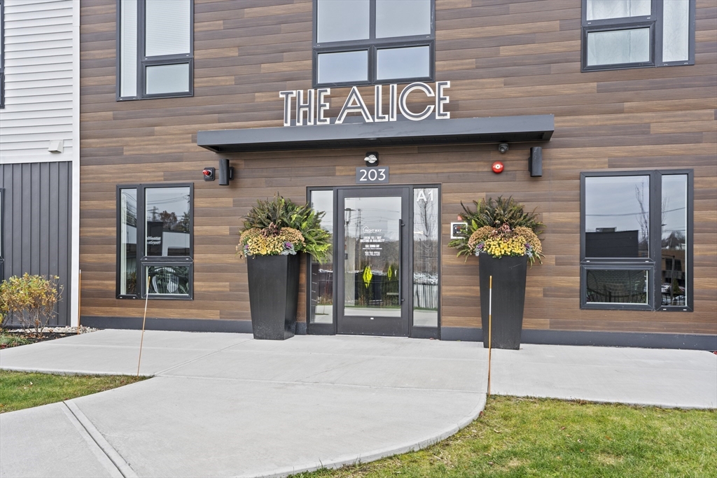 203 Lowell Street, Unit 103 Wilmington, MA 01887 - Photo 35 of 39 a front view of a building with garden