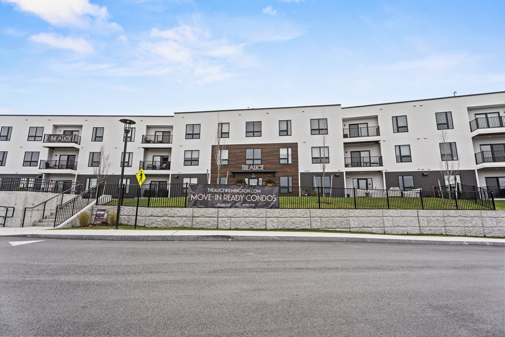 203 Lowell Street, Unit 103 Wilmington, MA 01887 - Photo 36 of 39 a view of a brick house next to a yard