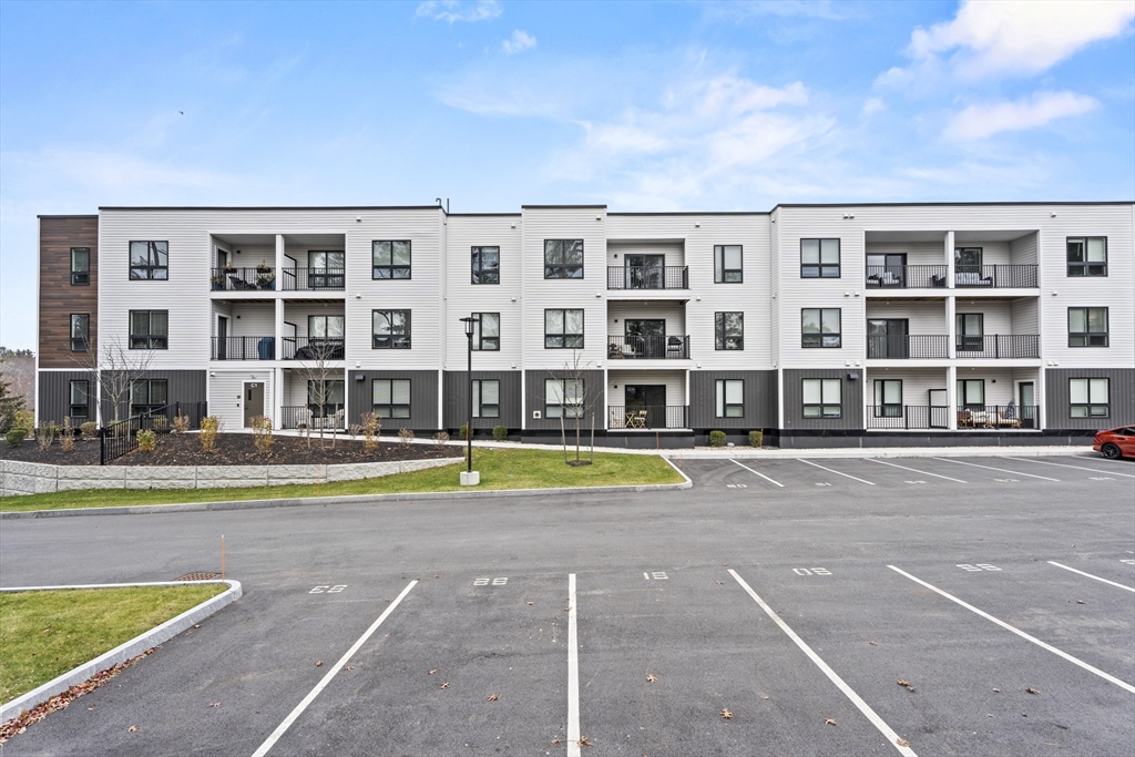 203 Lowell Street, Unit 103 Wilmington, MA 01887 - Photo 38 of 39 a view of pool with large windows and a big yard