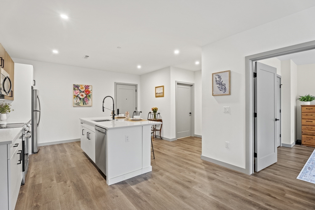 203 Lowell Street, Unit 103 Wilmington, MA 01887 - Photo 5 of 39 a kitchen with stainless steel appliances a white stove top oven and a refrigerator