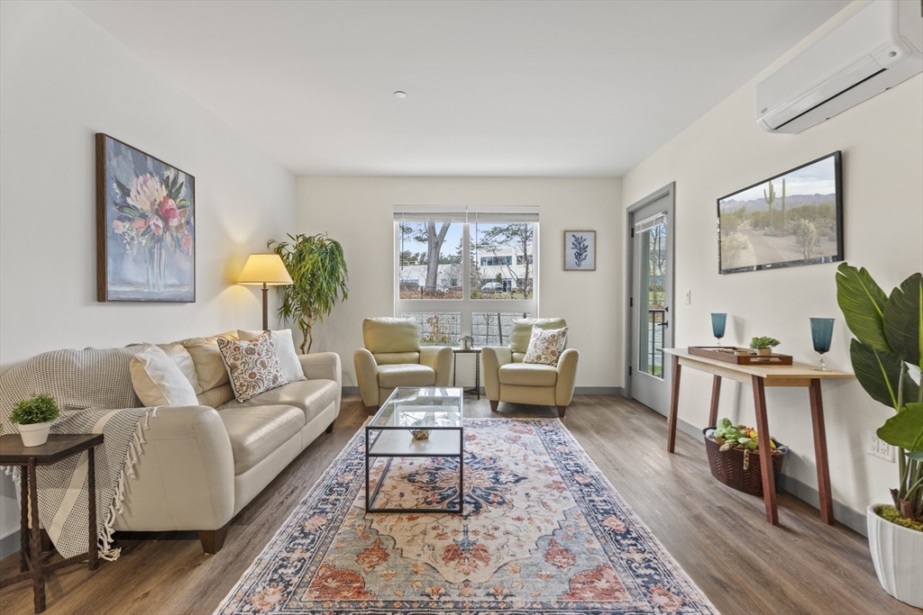 203 Lowell Street, Unit 103 Wilmington, MA 01887 - Photo 7 of 39 a living room with furniture and a wooden floor
