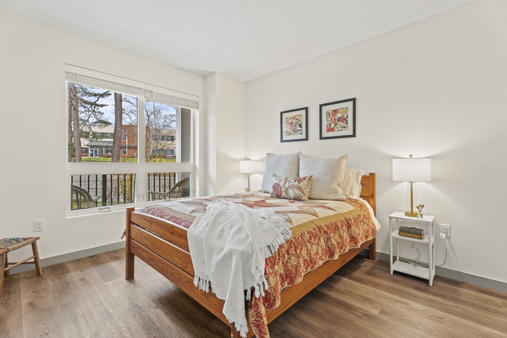 203 Lowell Street, Unit 103 Wilmington, MA 01887 - Photo 10 of 39 a bedroom with a bed a table and a window