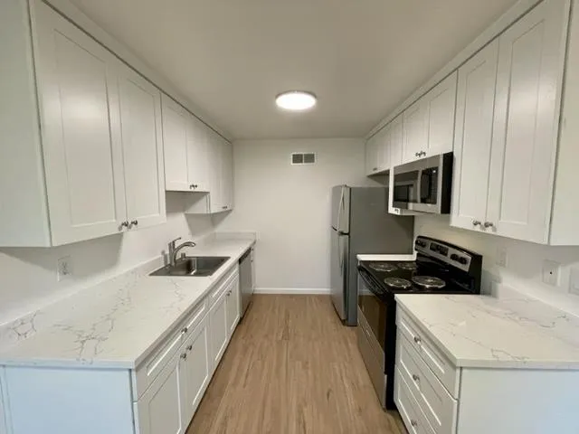 a kitchen with a sink a stove and refrigerator