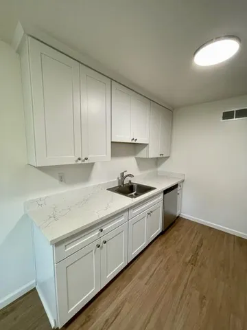 a kitchen with sink cabinets and wooden floor