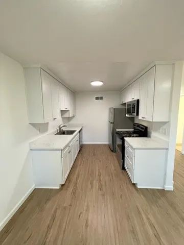 a view of kitchen with sink microwave and refrigerator
