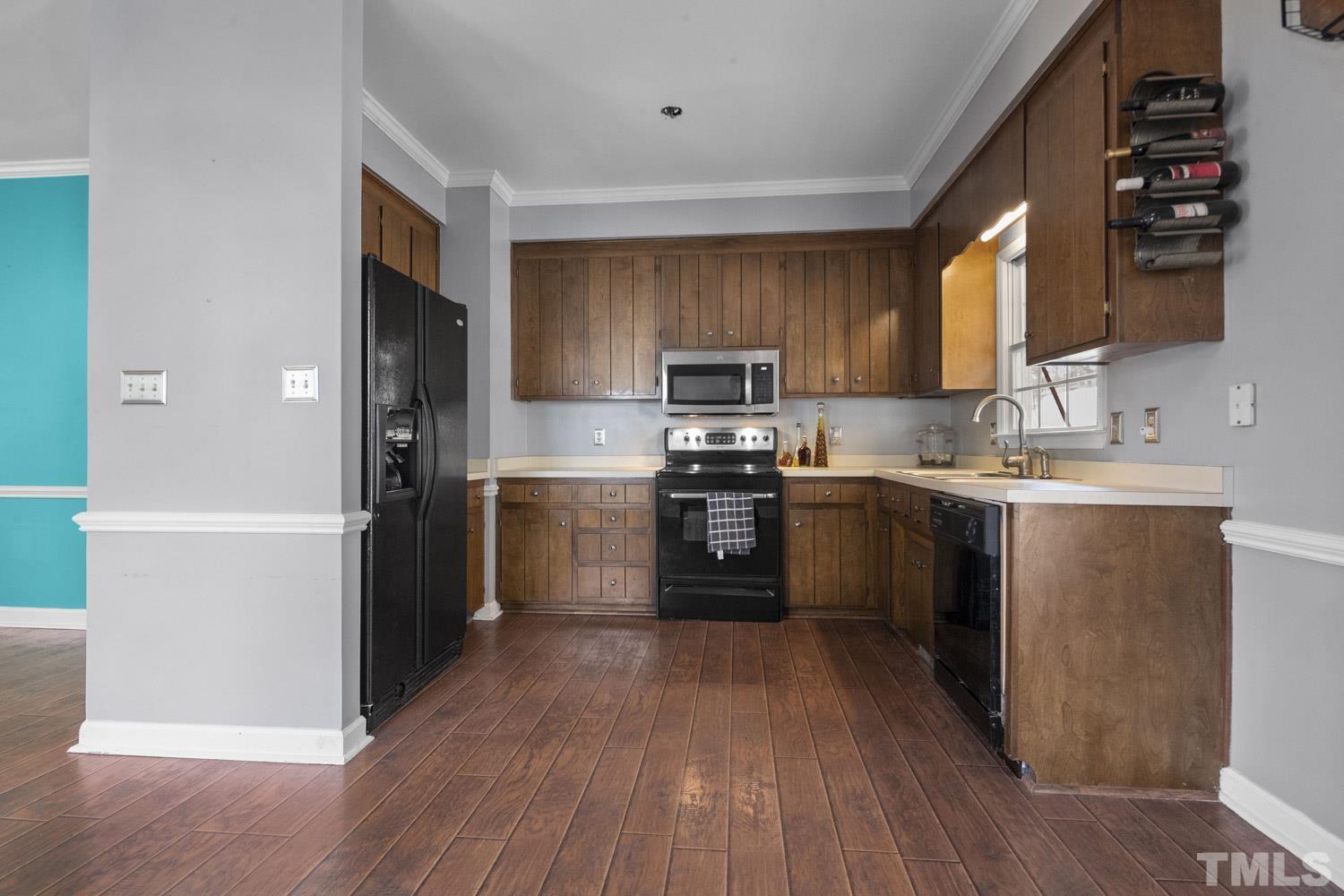 2109 Howson Road Raleigh, NC 27603 - Photo 11 of 36 a kitchen with stainless steel appliances granite countertop a refrigerator a sink dishwasher a stove top oven and a dining table with wooden floor