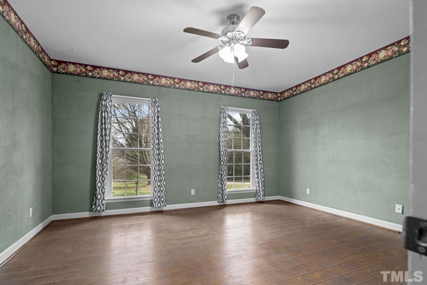2109 Howson Road Raleigh, NC 27603 - Photo 16 of 36 an empty room with wooden floor fan and windows
