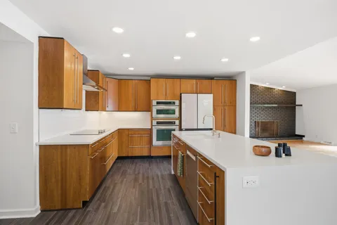 a view of a kitchen with a sink and wooden floor