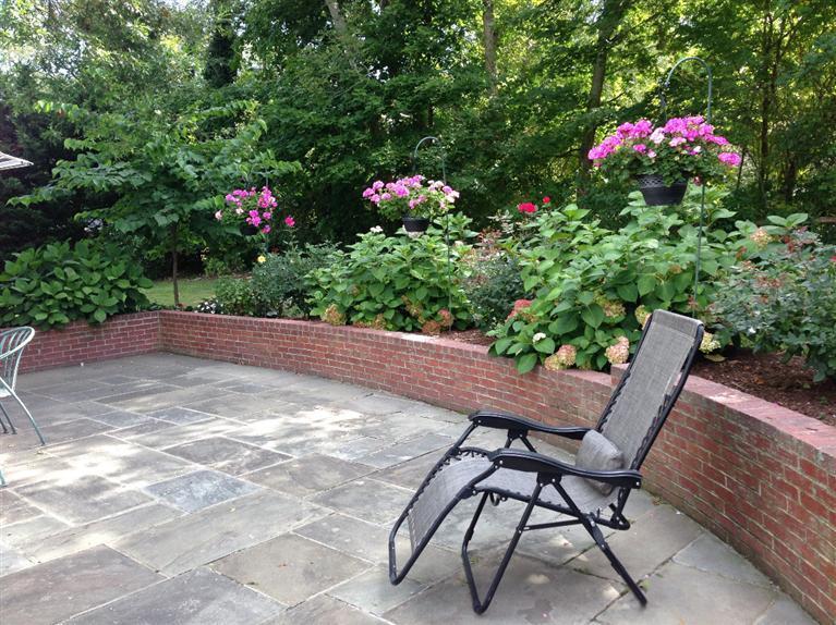 36 Rendezvous Lane Barnstable, MA 02630 - Photo 9 of 23 a wooden bench sitting in middle of flowers