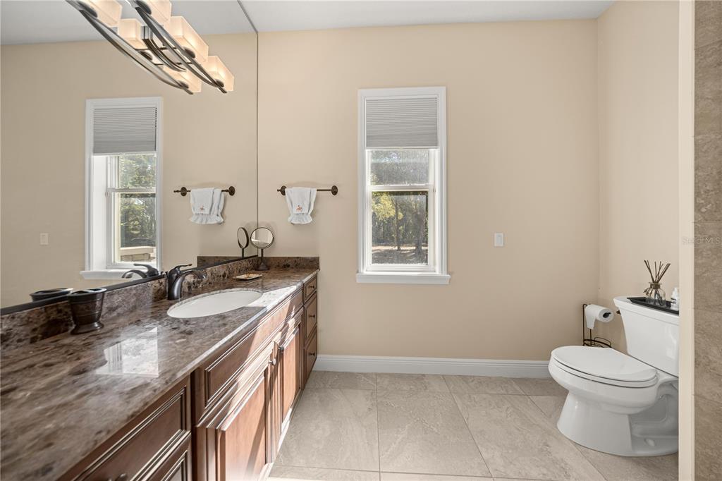 4681 Northwest 101st St Road Ocala, FL 34482 - Photo 22 of 33 a spacious bathroom with a granite countertop sink a toilet and a mirror